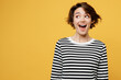 © ViDi Studio - Young surprised happy fun cheerful woman wears casual striped black and white shirt look aside on workspace area mock up isolated on plain yellow color background studio portrait. Lifestyle concept.