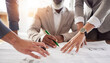 © Jessica L J/peopleimages.com - Business people, hands and meeting with blueprint in planning, strategy or brainstorming for construction at office. Hand of architect or group working in teamwork on floor plan, drawing or sketch