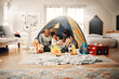 Love, home camping and happy family bonding, relax and enjoy time together having fun in living room. Happiness, tent and youth children playing with mother, father or parents in house adventure