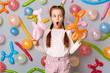 © sementsova321 - Funny shocked surprised little girl with pigtails standing against gray wall decorated with colorful balloons, looking away, sees surprise, excellent birthday present.