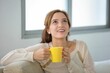 © Juan Carlos Rodriguez Garcia/Wirestock Creators - Woman holding yellow cup and looking up with smile in white background