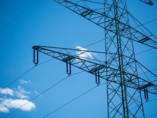 Sticker - Low angle shot of a transmission tower under a bright blue sky on a sunny day