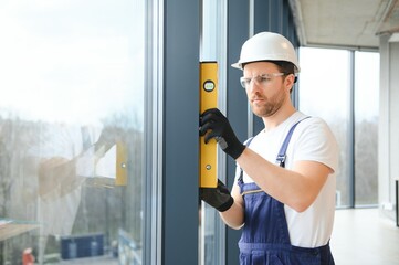 service man installing window with screwdriver