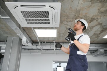 Wall Mural - Happy Male Technician Repairing Air Conditioner