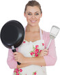 Young woman holding frying pan and spatula