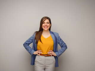 Poster - Isolated portrait of smiling woman in blue suit and yellow shirt.