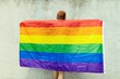Back view of human holding LGBT flag