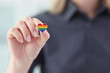 Woman holds small heart with LGBT flag colors in hand