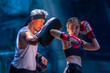 © somchairakin - Female kickboxing training with male trainer gives self-defense classes to female fighter at GYM. Asian beautiful young woman exercise with trainer at boxing gloves, uppercut short, boxing, training