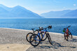 Tree bicycles on the Lago Maggiore promenade in Ascona, Switzerland with view to lake surrounded mountains