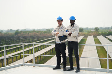  Electrician engineer with white helmet working at a photovoltaic farm, checking and maintenance equipment with instruments at industry solar power.