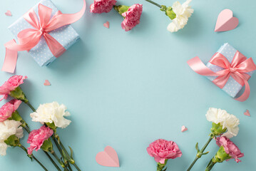 Wall Mural - Mother's Day memories concept. Top view flat lay photo of gift boxes with pink ribbons, carnation flowers, and pink paper hearts on pastel blue background with empty space for text or advert