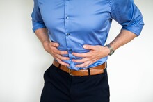 Man Wearing Formal Clothes With His Hand On His Stomach Indicating Pain