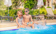 © Анна Лизгунова - Children sitting and laughing on the side of the pool.Splash water in the poolFunny kids near the pool