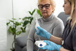 © Angelov - Young high-skilled pleasant woman doctor putting on nebulizer mask on face of her elderly female patient to make inhalation when visitng him at home. Flu, cold and cough treatment