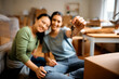 © Drazen - Close up of female roommates holding keys while moving into new home.