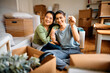 © Drazen - Happy female couple holding key while after moving into their new apartment.