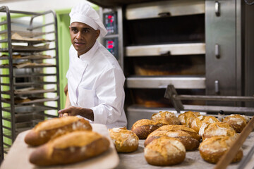 Wall Mural - Baker pulls hot bread out of the oven