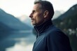 © Robert MEYNER - Photography in the style of pensive portraiture of a pleased man in his 50s wearing a comfortable tracksuit against a mountain lake or alpine background. Generative AI