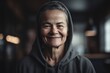 © Robert MEYNER - Portrait of a smiling senior woman wearing hoodie in a cafe