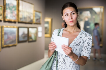 Wall Mural - Asian female visitor at exhibition in museum