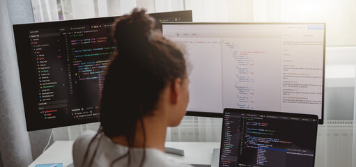 Wall Mural - back view of woman coding on computer, professional female programmer working in room