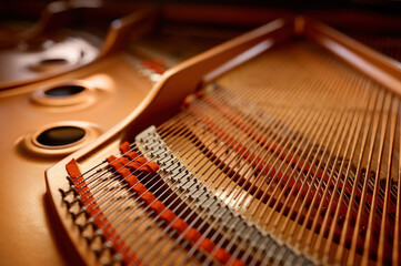 Selective focus closeup view on hammers and strings inside grand piano