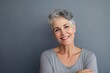 © pixardi - Mature Woman Smiling on Grey Wall Headshot. Photo generative AI