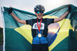© Azeemud-Deen Jacobs/peopleimages.com - Winner sports, happy woman from brazil with flag and gold medal winning athlete, outdoor cycling race or triathlon. Happiness, win and cyclist with smile, fitness and world record with national pride