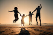 © C. Daniels/peopleimages.com - Beach silhouette, sunset and a family jump for freedom, summer energy or travel. Happy, nature and back of a mother, father and children holding hands while jumping at the ocean for celebration