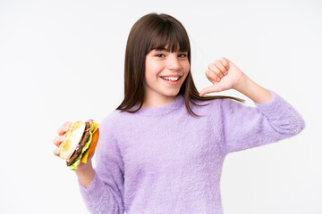 Wall Mural - Little caucasian girl holding a burger over isolated background proud and self-satisfied