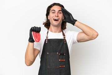 Butcher handsome man wearing an apron and serving fresh cut meat isolated on white background with surprise expression