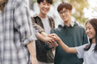 © NINENII - Student shake hands together at University place. team study concept.