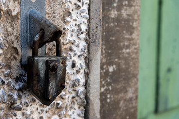 Wall Mural - old metal lock atached on the wall of an old building