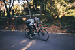 © Azeemud/peopleimages.com - Cycling, nature and relax with man on road for training, workout or cardio exercise. Adventure, extreme sports and speed with male cyclist on bike in forest park for performance, challenge or break