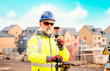 © Iryna - Surveyor builder site engineer with theodolite total station at construction site outdoors during surveying work