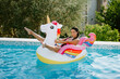 © shevtsovy - sexy woman lay on inflatable beach floaty toy unicorn in swimming pool. Sexy female in swimsuit on vacations relax on inflatable mattress in swimming pool outdoors with pool toys. Summer vacation time