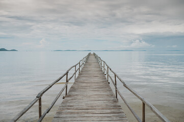 Picturesque scenery of empty wooden pier placed on rippling sea under cloudy sky