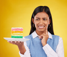 Sticker - Upset woman, rainbow cake and studio while thinking of birthday celebration, disaster or mistake. Face of Indian gen z female with dessert food with color, foul smell or bad idea on yellow background