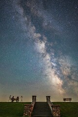 Wall Mural - Vertical shot of people on the bench against the background of the starry sky.