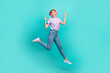 © deagreez - Full size photo of cool cheerful woman bob hairdo striped t-shirt jumping show rocknroll horns symbol isolated on teal color background