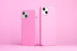 © iso100production - set of two iPhone 15 and 14 Plus or iPhone 13 and 13 mini in pink cases back side view isolated on pink background, monochrome colours phone case mock up
