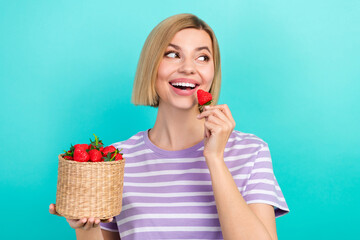 Sticker - Portrait of adorable satisfied woman stylish t-shirt hold basket with strawberry look empty space isolated on teal color background