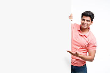 young indian man showing and pointing of big white board with copy space