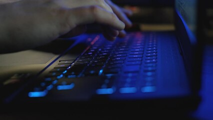 Male hands typing text on a laptop keyboard, close-up