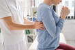 © LIGHTFIELD STUDIOS - cropped view of physiotherapist examining injured back of woman in consulting room.