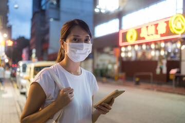 Canvas Print - Woman wear face mask and use mobile phone in city at night