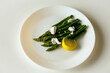 Ready asparagus on a white plate ready to eat, healthy food for the body, source of antioxidants.