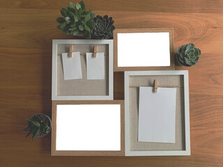 two rectangular photo frames png, two frames with notes attached with a wooden clothespin, decorated with 4 small green plants, walnut background