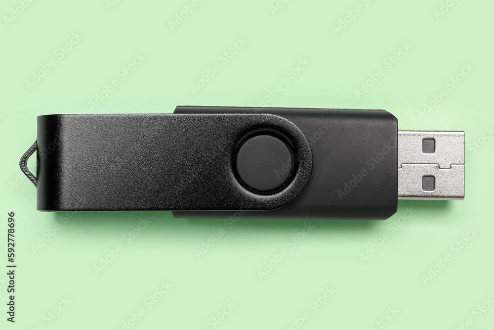 Black USB flash drive on green background